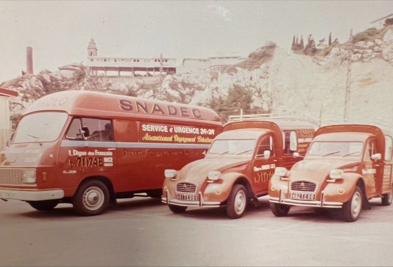 Ancienne flotte de trois fourgons de service blancs et rouges SNADEC.